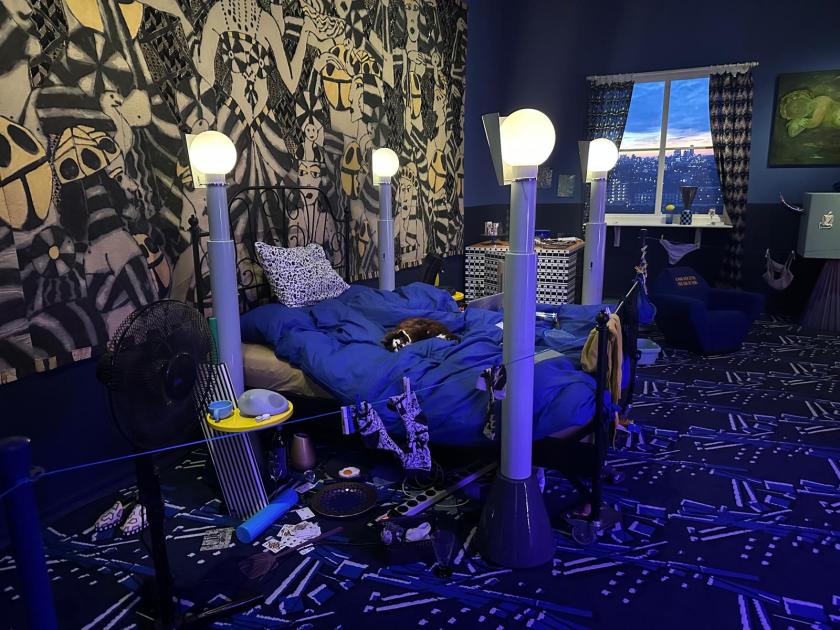 Welcome to the dreamhouse Dwaal door een levensgroot droomhuis in het Groninger Museum. Alle ruimtes – van de woonkamer en de slaapkamer tot de tuin – staan in deze tentoonstelling vol met postmodern design uit de eigen collectie van het museum. Een haast filmische wereld komt tot leven waarin details, contrasten, kleuren en humor centraal staan. Van rondslingerend speelgoed tot gebruikte asbakken – de kamers ademen het dagelijks leven en spelen met de imperfectie die echte interieurs kenmerkt. Het Groninger Museum beschikt over de grootste museale collectie postmodern design in het land, opgebouwd sinds de jaren tachtig onder leiding van voormalig directeur Frans Haks. In Welcome to the Dreamhouse! is werk te zien van invloedrijke ontwerpers als Alessandro Mendini, Ettore Sottsass en andere leden van de Memphis-groep, waaronder Michele de Lucchi, Masanori Umeda, George Sowden en Nathalie du Pasquier. Ook is er aandacht voor Philippe Starck, ontwerper van een van de paviljoens van het museum, en voor ontwerpers als Studio Job, Maarten Baas en Jaime Hayon, die elk op hun eigen manier het postmodernisme een nieuwe invulling geven. De tentoonstelling is vormgegeven door Marloes en Wikke, gerenommeerde scenografen voor theater en opera, die met hun onconventionele stijl zorgen voor een speelse en theatrale presentatie. Het Groninger Museum 2025 Ontwerp en Samenstelling Marloes en Wikke Conservator Ruud Schenk Lichtontwerp Yuri Schreuders Geluidsontwerp Daan Hofman Styling assistent Juliette Mout Grafische vormgeving Rudo Menge Hoofd collectie Marieke van Loenhout Stage M\\W Menno Meijners Peter Duel
