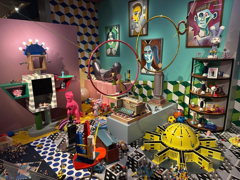 Welcome to the dreamhouse Dwaal door een levensgroot droomhuis in het Groninger Museum. Alle ruimtes – van de woonkamer en de slaapkamer tot de tuin – staan in deze tentoonstelling vol met postmodern design uit de eigen collectie van het museum. Een haast filmische wereld komt tot leven waarin details, contrasten, kleuren en humor centraal staan. Van rondslingerend speelgoed tot gebruikte asbakken – de kamers ademen het dagelijks leven en spelen met de imperfectie die echte interieurs kenmerkt. Het Groninger Museum beschikt over de grootste museale collectie postmodern design in het land, opgebouwd sinds de jaren tachtig onder leiding van voormalig directeur Frans Haks. In Welcome to the Dreamhouse! is werk te zien van invloedrijke ontwerpers als Alessandro Mendini, Ettore Sottsass en andere leden van de Memphis-groep, waaronder Michele de Lucchi, Masanori Umeda, George Sowden en Nathalie du Pasquier. Ook is er aandacht voor Philippe Starck, ontwerper van een van de paviljoens van het museum, en voor ontwerpers als Studio Job, Maarten Baas en Jaime Hayon, die elk op hun eigen manier het postmodernisme een nieuwe invulling geven. De tentoonstelling is vormgegeven door Marloes en Wikke, gerenommeerde scenografen voor theater en opera, die met hun onconventionele stijl zorgen voor een speelse en theatrale presentatie. Het Groninger Museum 2025 Ontwerp en Samenstelling Marloes en Wikke Conservator Ruud Schenk Lichtontwerp Yuri Schreuders Geluidsontwerp Daan Hofman Styling assistent Juliette Mout Grafische vormgeving Rudo Menge Hoofd collectie Marieke van Loenhout Stage M\\W Menno Meijners Peter Duel